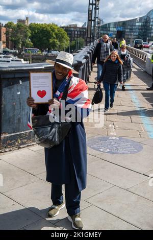 Westminster, Londra, Regno Unito. 18th Settembre 2022. Un uomo tiene un messaggio per la regina e re Carlo. Pianatori che attraversano Lambeth Bridge subito prima di entrare nei Victoria Tower Gardens. La gente ha accodato durante la notte per vedere sua Maestà la Regina sdraiata nello Stato nella Westminster Hall. Molti di loro portavano coperte dopo una notte fredda, ma erano molto felici di avvicinarsi al Palazzo di Westminster per rendere i loro ultimi rispetti alla Regina Elisabetta II prima che il suo funerale si svolesse domani. Credit: Maureen McLean/Alamy Live News Foto Stock