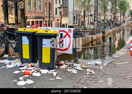 Amsterdam, Paesi Bassi - Agosto 2022: Rifiuti e lettiera scaricati accanto ai bidoni dei rifiuti in una strada nel centro di Amsterdam Foto Stock