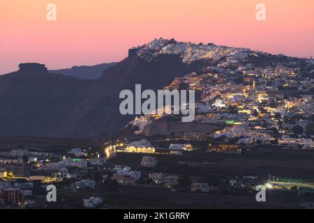 Vista sulla città e sulla campagna di Thera, la capitale di Santorini, nelle isole greche della Grecia, su una collina di roccia vulcanica durante un vibrante, Foto Stock