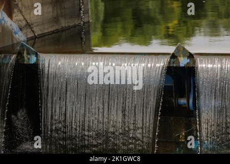 Acqua che scorre attraverso una chiusa su un fiume. Foto Stock
