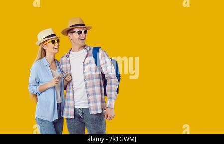 Un giovane uomo e una donna caucasici positivi che vanno in tour guardando in lontananza con delizia Foto Stock