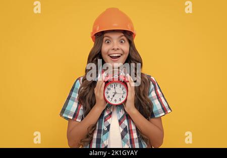 stupito bambino con capelli ricci in costruzione casco tenere sveglia, scadenza Foto Stock