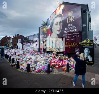 I membri del pubblico visitano un murale alla Regina Elisabetta II sulla Shankill Road a Belfast, davanti al minuto di silenzio nazionale in memoria della Regina Elisabetta II Il paese osserva un minuto di silenzio per ricordare la Regina, con persone invitate a celebrare l'occasione privatamente a casa, a casa o per strada, o in occasione di eventi e di veglie della comunità. Data immagine: Domenica 18 settembre 2022. Foto Stock