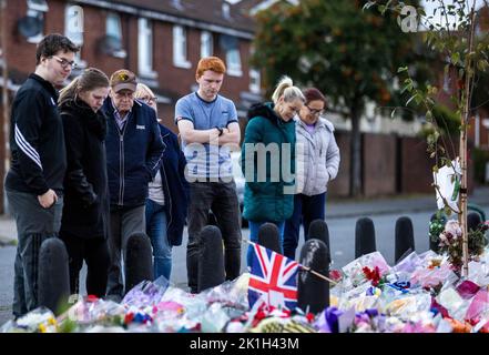 I membri del pubblico visitano un murale alla Regina Elisabetta II sulla Shankill Road a Belfast, davanti al minuto di silenzio nazionale in memoria della Regina Elisabetta II Il paese osserva un minuto di silenzio per ricordare la Regina, con persone invitate a celebrare l'occasione privatamente a casa, a casa o per strada, o in occasione di eventi e di veglie della comunità. Data immagine: Domenica 18 settembre 2022. Foto Stock