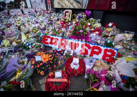 I membri del pubblico visitano un murale alla Regina Elisabetta II sulla Shankill Road a Belfast, davanti al minuto di silenzio nazionale in memoria della Regina Elisabetta II Il paese osserva un minuto di silenzio per ricordare la Regina, con persone invitate a celebrare l'occasione privatamente a casa, a casa o per strada, o in occasione di eventi e di veglie della comunità. Data immagine: Domenica 18 settembre 2022. Foto Stock