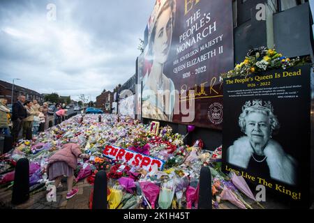 I membri del pubblico visitano un murale alla Regina Elisabetta II sulla Shankill Road a Belfast, davanti al minuto di silenzio nazionale in memoria della Regina Elisabetta II Il paese osserva un minuto di silenzio per ricordare la Regina, con persone invitate a celebrare l'occasione privatamente a casa, a casa o per strada, o in occasione di eventi e di veglie della comunità. Data immagine: Domenica 18 settembre 2022. Foto Stock