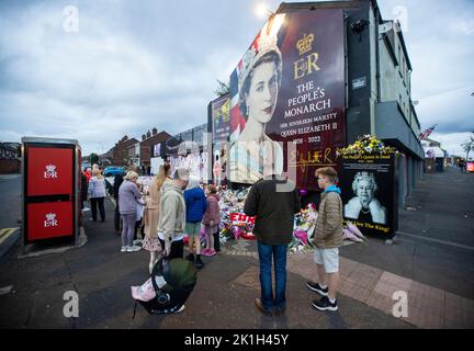 I membri del pubblico visitano un murale alla Regina Elisabetta II sulla Shankill Road a Belfast, davanti al minuto di silenzio nazionale in memoria della Regina Elisabetta II Il paese osserva un minuto di silenzio per ricordare la Regina, con persone invitate a celebrare l'occasione privatamente a casa, a casa o per strada, o in occasione di eventi e di veglie della comunità. Data immagine: Domenica 18 settembre 2022. Foto Stock