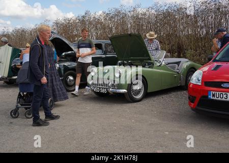 Exeter, Regno Unito-Agosto 2022: Uomini caucasici in visita a una mostra di auto classica presso Greendale Farm vicino Exeter con un Triumph TR3 1959 in primo piano Foto Stock