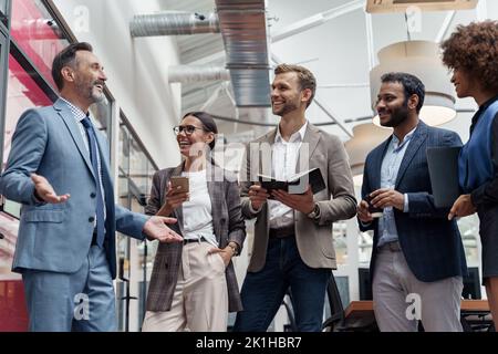 Gruppo multietnico di uomini d'affari che parlano in ufficio durante la pausa. Concetto di lavoro di squadra Foto Stock