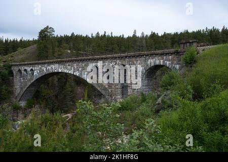 Dombas, Norvegia - 22 giugno 2022: Jora Bru è un ponte ferroviario sulla Rauma Railway sul fiume Jora. Innlandet. Norge. E' un ponte ad arco in pietra. Foto Stock