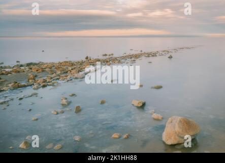 Un percorso di pietre ricoperte di cristalli di sale che vanno nel lago di sale Elton sullo sfondo del tramonto, regione di Volgograd Foto Stock