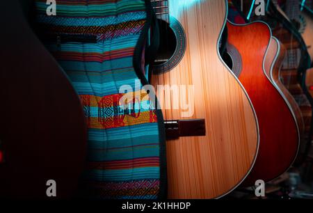 Una serie di chitarre acustiche multicolore in un negozio Foto Stock