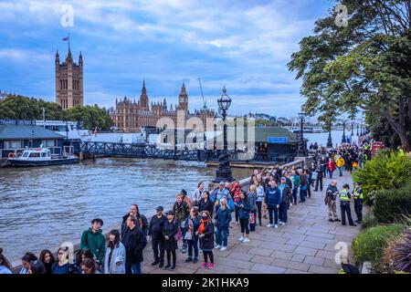 Le persone fanno coda lungo le rive del tamigi per ore per rendere omaggio alla regina Elisabetta II, che si trova nella sala di Westminster. Foto Stock