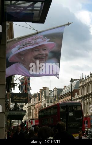 Una bandiera con la Regina fuori da un negozio su Piccadilly il 18 settembre 2022, la notte prima del funerale durante il periodo di lutto, Londra, Regno Unito Foto Stock