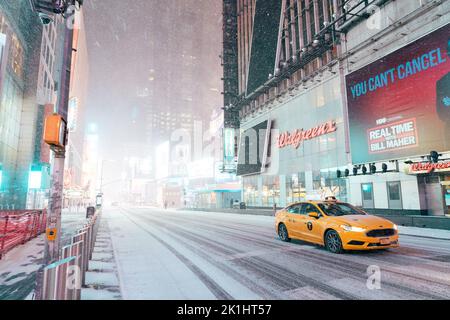 NYC Taxi guidando attraverso Times Square in una tempesta di neve Foto Stock