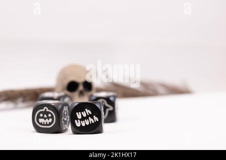 Dadi magici con simboli per giochi fantasy e un cranio e una piuma Foto Stock