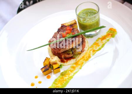 Deliziosa bistecca di manzo con salsa di mele servita su piatto bianco Foto Stock