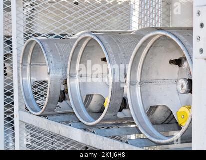 Houston, Texas USA 09-18-2022: Tre bombole di gas di petrolio liquido immagazzinate orizzontalmente in una gabbia di sicurezza metallica, vista ad angolo a livello degli occhi con sportello aperto. Foto Stock