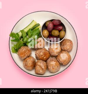 Polpette greche keftedes su sfondo a colori. Cibo tradizionale. Concetto di fotografia creativa. Vista dall'alto, spazio di copia Foto Stock