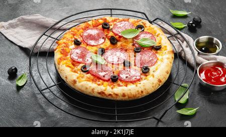 Pizza peperoni appena sfornata su fondo scuro. Concetto gustoso di cibo fatto in casa. Foto Stock