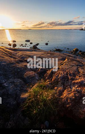 Splendida vista sulla costa rocciosa e la scogliera e sul Mar Baltico a Hanko, Finlandia, al tramonto in estate. Foto Stock