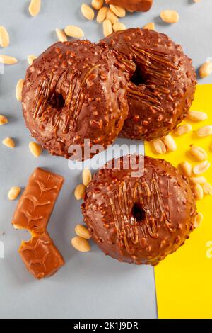 Tre ciambelle croccanti al cioccolato ghiacciato. Foto Stock