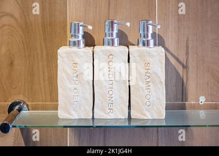 Articoli da toeletta bottiglie in bagno in un hotel di lusso o in una casa moderna. Set di contenitori per doccia, gel doccia per il corpo, shampoo e balsamo per capelli in ceramica wit Foto Stock
