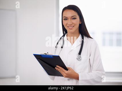 Che cosa sembra essere il problema oggi. Ritratto di un giovane e attraente medico che tiene un clipboard. Foto Stock