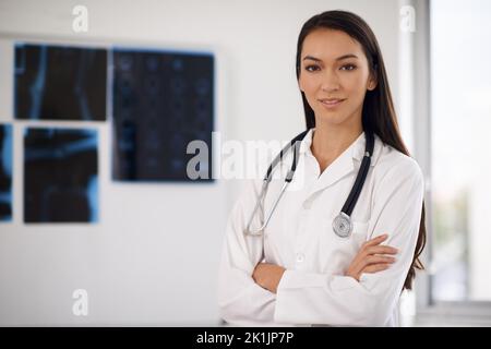 Mettete la vostra fiducia nelle sue mani. Ritratto di un giovane medico fiducioso in piedi con le braccia piegate. Foto Stock