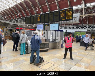 I membri del pubblico guardano le schede di viaggio a Paddington Station, Londra, poiché tutte le linee ferroviarie tra Slough e Paddington sono bloccate a causa di danni ai cavi elettrici sospesi, ha detto Great Western Railway. Ciò sta disturbando i viaggi per i lutto che tentano di viaggiare a Londra per il funerale statale della Regina Elisabetta II da Reading o dall'aeroporto di Heathrow. Sono interessati i servizi gestiti da GWR, Heathrow Express e dalla linea Elizabeth. Data immagine: Lunedì 19 settembre 2022. Foto Stock