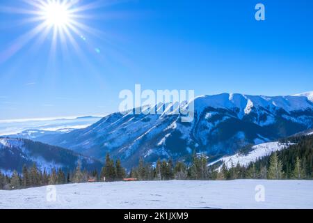 Slovacchia. Stazione sciistica Jasna. Sole su piste da sci vuote e terreno montagnoso Foto Stock