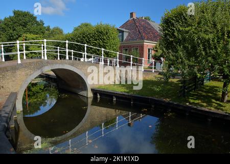 ENKHUIZEN, PAESI BASSI - 11 SETTEMBRE 2022: Zuiderzeemuseum, un museo all'aperto sulla riva di Ijsselmeer, con canali, barche e ponti Foto Stock