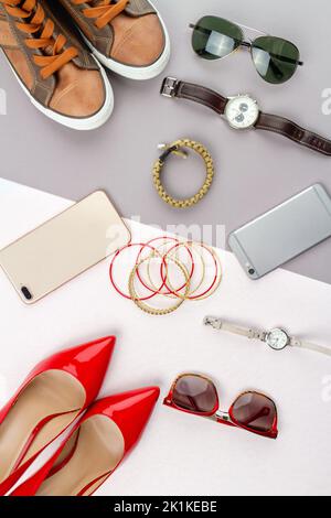 Composizione piatta di accessori per donna e uomo. Immagine verticale vista dall'alto contrasto di effetti personali maschili e femminili. Foto Stock