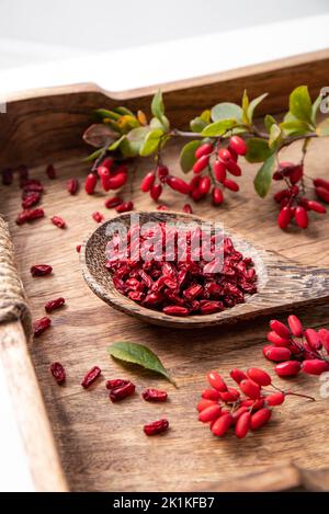 Mucchio di vulgaris di Berberis secchi anche conosciuto come barberry comune, barberry europeo o barberry sul piatto in kicthen domestico. fru rossa medicinale erboristico commestibile Foto Stock