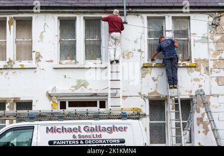 Pittori locali e decoratori al lavoro su una casa in Ardara, Contea di Donegal, Irlanda Foto Stock