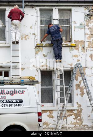 Pittori locali e decoratori al lavoro su una casa in Ardara, Contea di Donegal, Irlanda Foto Stock