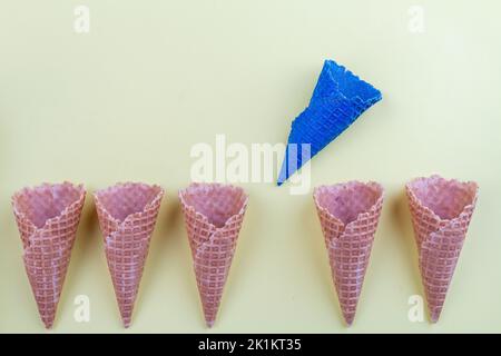 Cialde a cono con gelato blu tra i normali. Distinguiti dagli altri concetti. Foto Stock