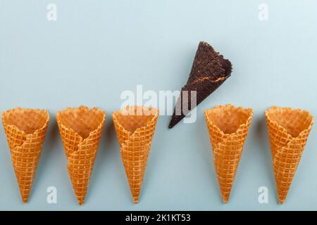 La cialda a cono con gelato marrone si distingue da quelle tradizionali. Foto Stock
