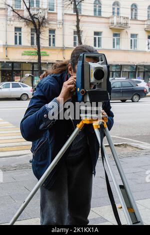 Ingegnere Surveyor che misura con una teodolite. Foto Stock