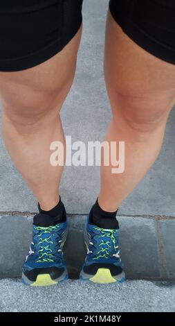 Le gambe dell'uomo si allungano prima di andare a correre. Foto Stock