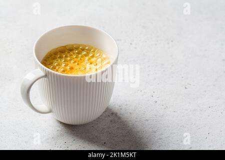 Latte di luna turmerico dorato in una tazza bianca. Ayurveda bere, stile di vita sano, rimedio per l'insonnia. Foto Stock