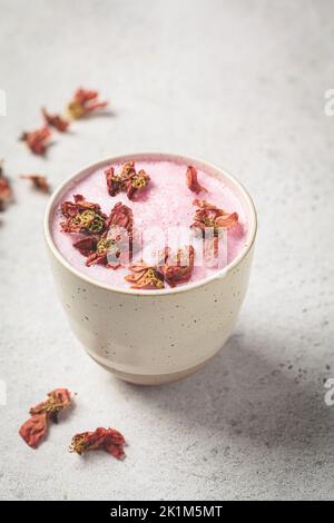Latte di luna di fiore rosa in una tazza bianca. Ayurveda bere, stile di vita sano, rimedio per l'insonnia. Foto Stock