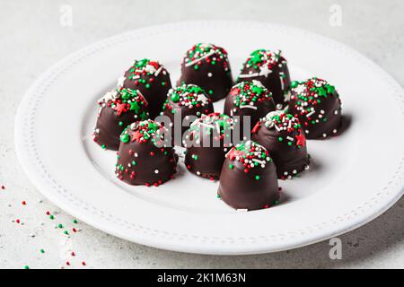 Palline di cioccolato di Natale fatte a mano con spolverini per le vacanze. Regalo per le feste fai da te, ricetta per dessert. Foto Stock