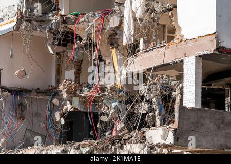 Demolito edificio e cumulo di detriti. Palo di pietra, mattoni, tondini e relitto di cemento. Foto di alta qualità Foto Stock