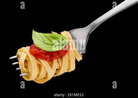 Spaghetti italiani su forchetta su sfondo nero Foto Stock