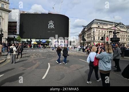 Funerali di Stato di sua Maestà la Regina Elisabetta II, Londra, Regno Unito, lunedì 19th settembre 2022. Un tributo nero pieno a sua Maestà la Regina su un grande schermo in Piccadilly Circus. Foto Stock