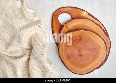 Tavole da taglio in legno o tavole da cucina fai da te su un tavolo in cemento leggero e asciugamano da cucina con spazio copia. Foto Stock