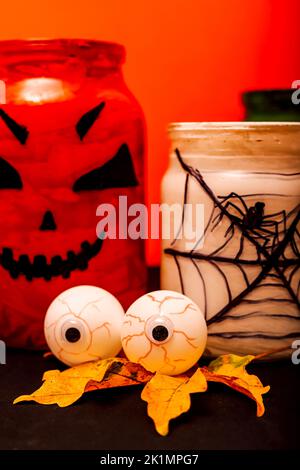 Halloween composizione di occhi, zucca e un vaso con un ragno Foto Stock