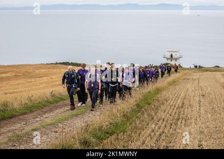 I bambini e gli insegnanti della scuola di Gordonstoun segnano il funerale di stato della regina Elisabetta II camminando fino alla torre di guardia della guardia costiera nella vicina Covesea fu aperta dal principe Filippo nel 1955 e fu usata da re Carlo III durante il suo periodo come capitano del servizio di guardia costiera a Gordonstoun. Data immagine: Lunedì 19 settembre 2022. Foto Stock