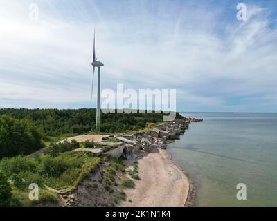 Vista aerea dei forti settentrionali di Liepaja, vecchie fortificazioni abbandonate sulla costa del Mar Baltico in Lettonia. Turbina eolica di grandi dimensioni Foto Stock